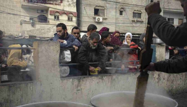 Des Palestiniens font la queue pour recevoir un repas gratuit à Rafah, dans la bande de Gaza, le jeudi 21 décembre 2023. © Fatima Shbair, AP